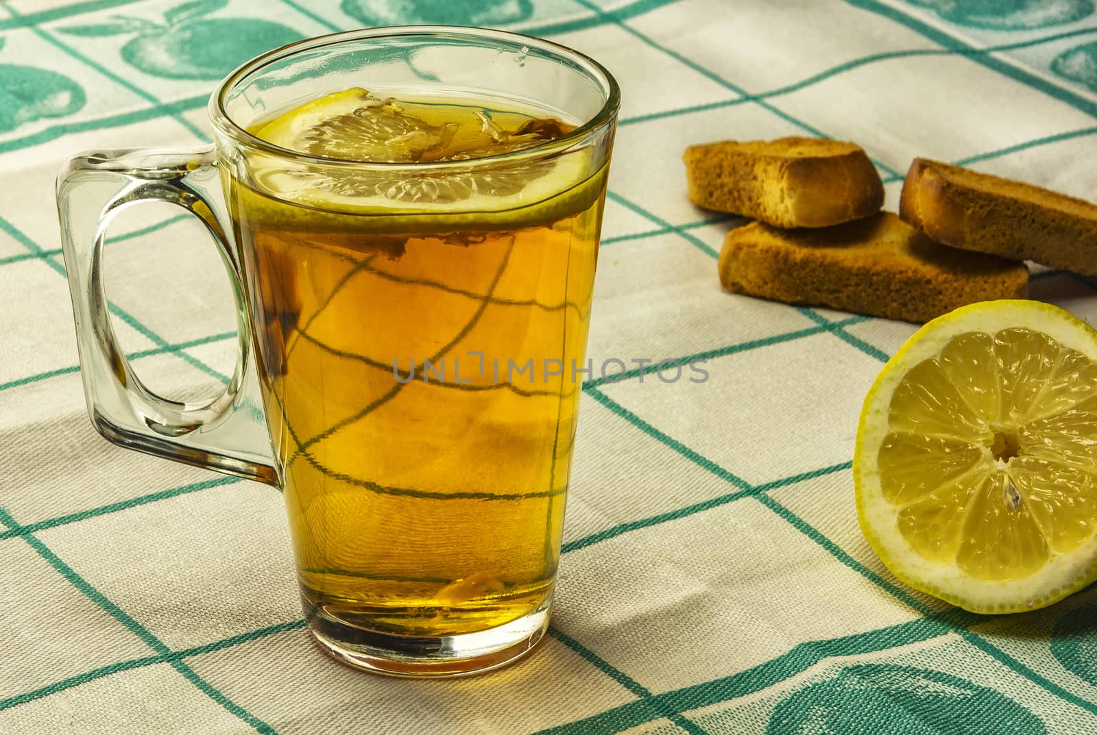 On the table is a glass of tea with lemon and lie vanilla biscui by Grommik