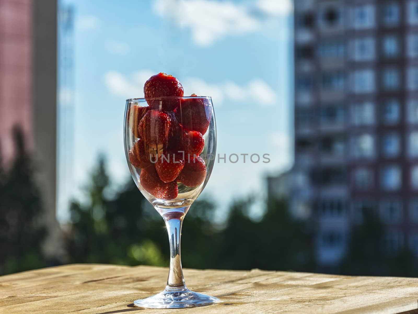 Strawberries in a glass against the blue sky