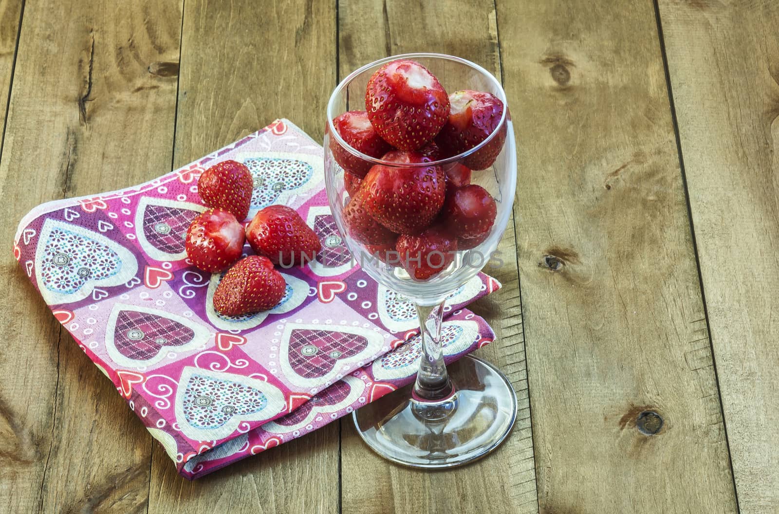 Berry strawberries in a glass fouger on a wooden surface