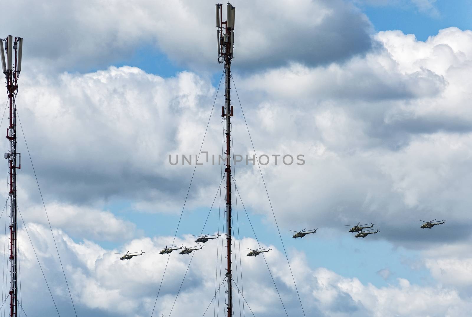 Against the background of a cloudy sky military helicopters fly
