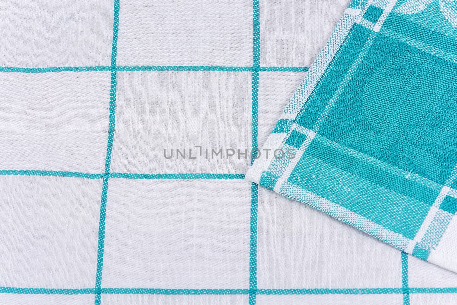 The edge of a tissue napkin with a white-green pattern is wrapped in an angle to the middle