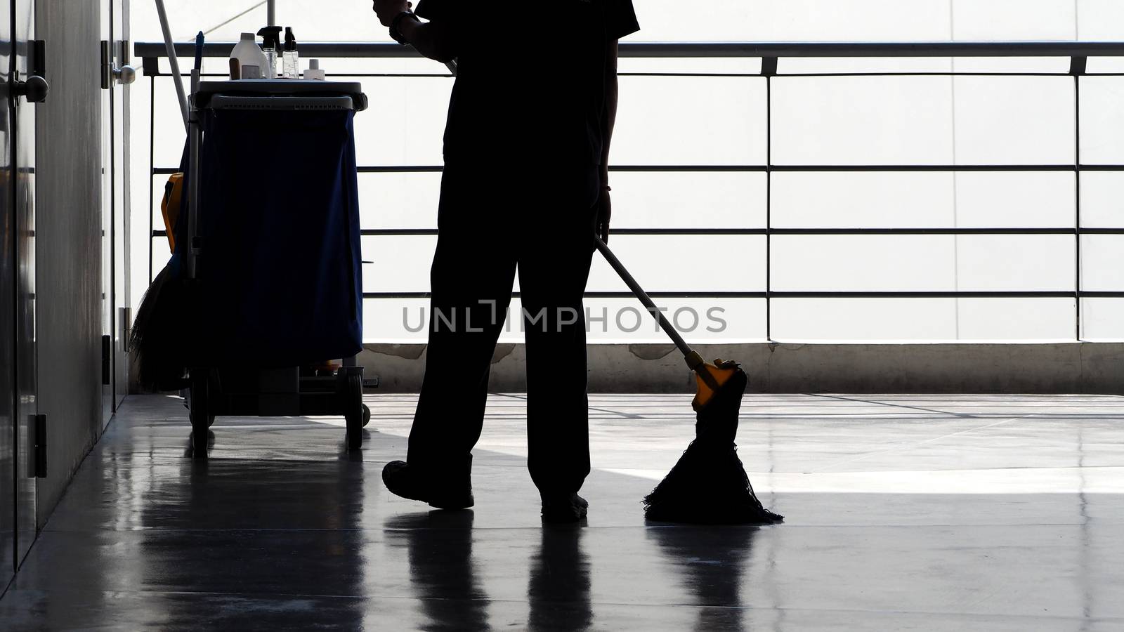 Silhouette of cleaning service people sweeping floor  by gnepphoto