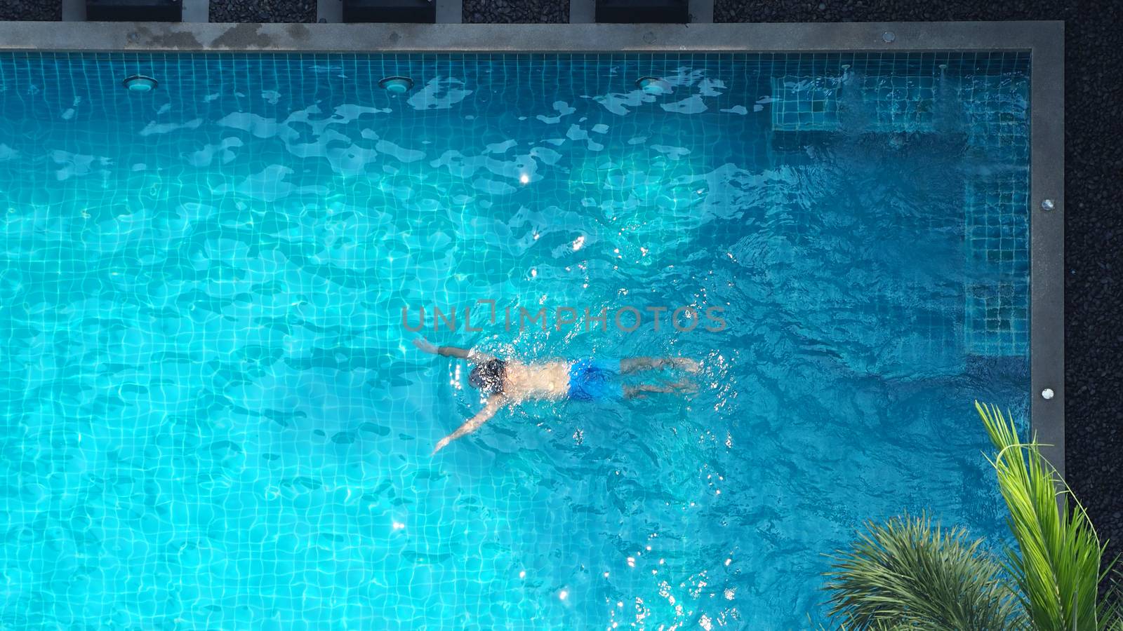 Water streaming corner in swimming pool top view by gnepphoto