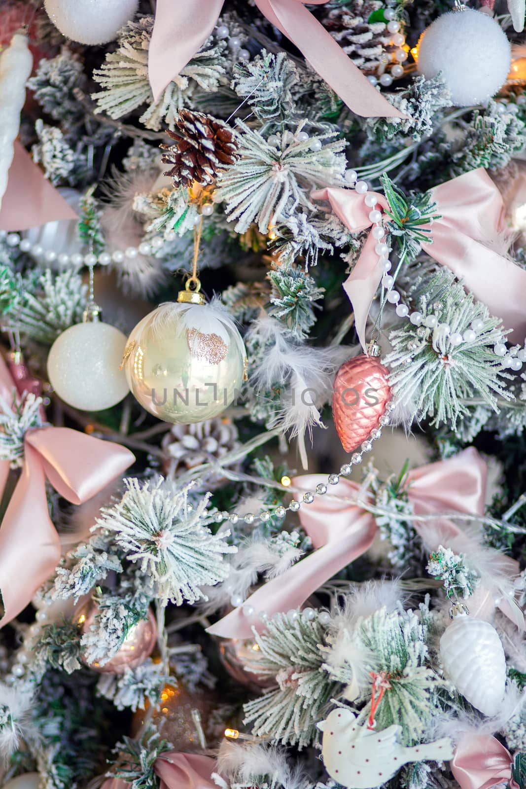 Christmas tree decoration close-up. Christmas tree decor elements. Background for postcards. Beautiful pale pink bow