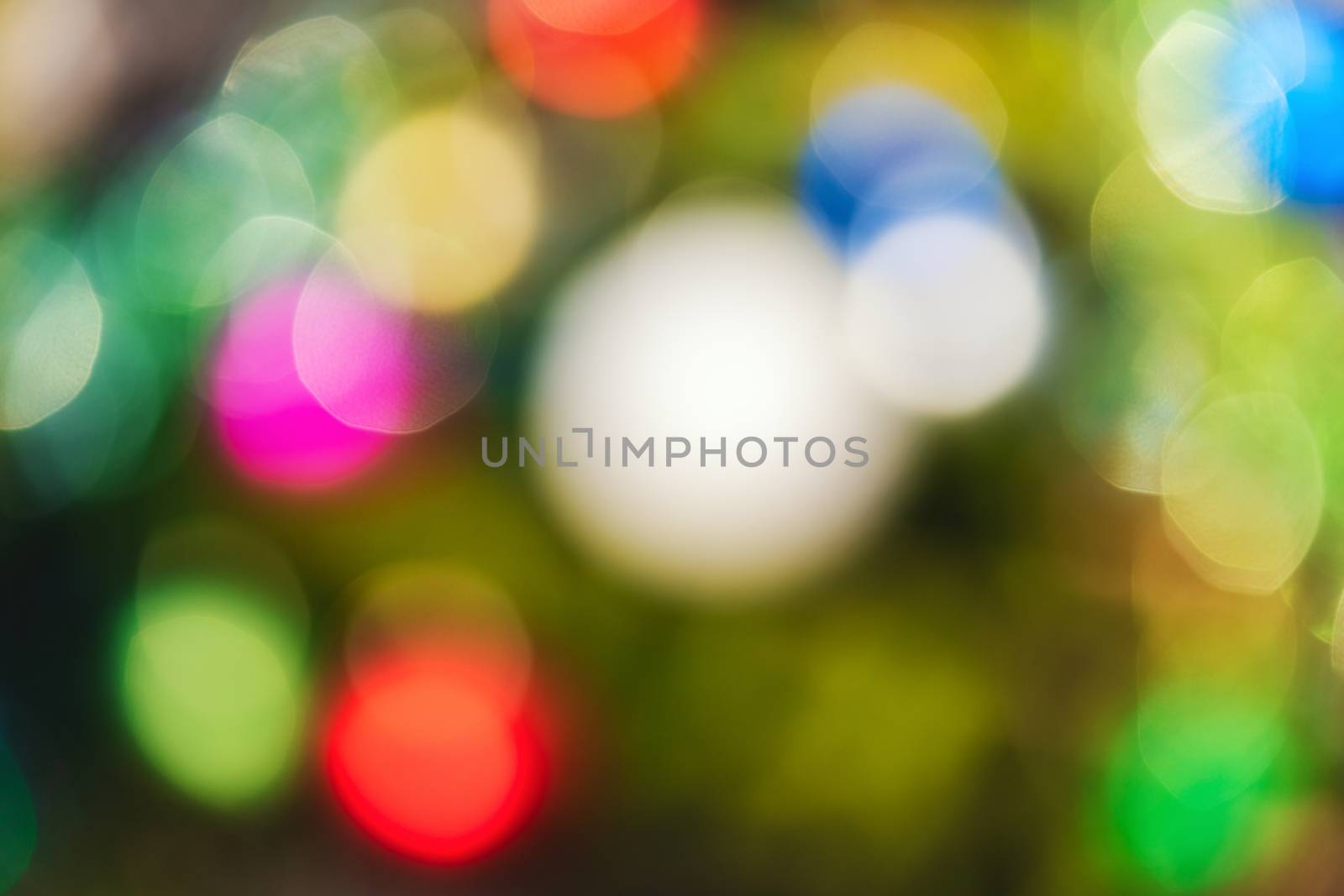 Defocused colorful Christmas holiday decorations, abstract blurry bokeh background effect. Out of focus glowing lights celebration texture for use at graphic design.