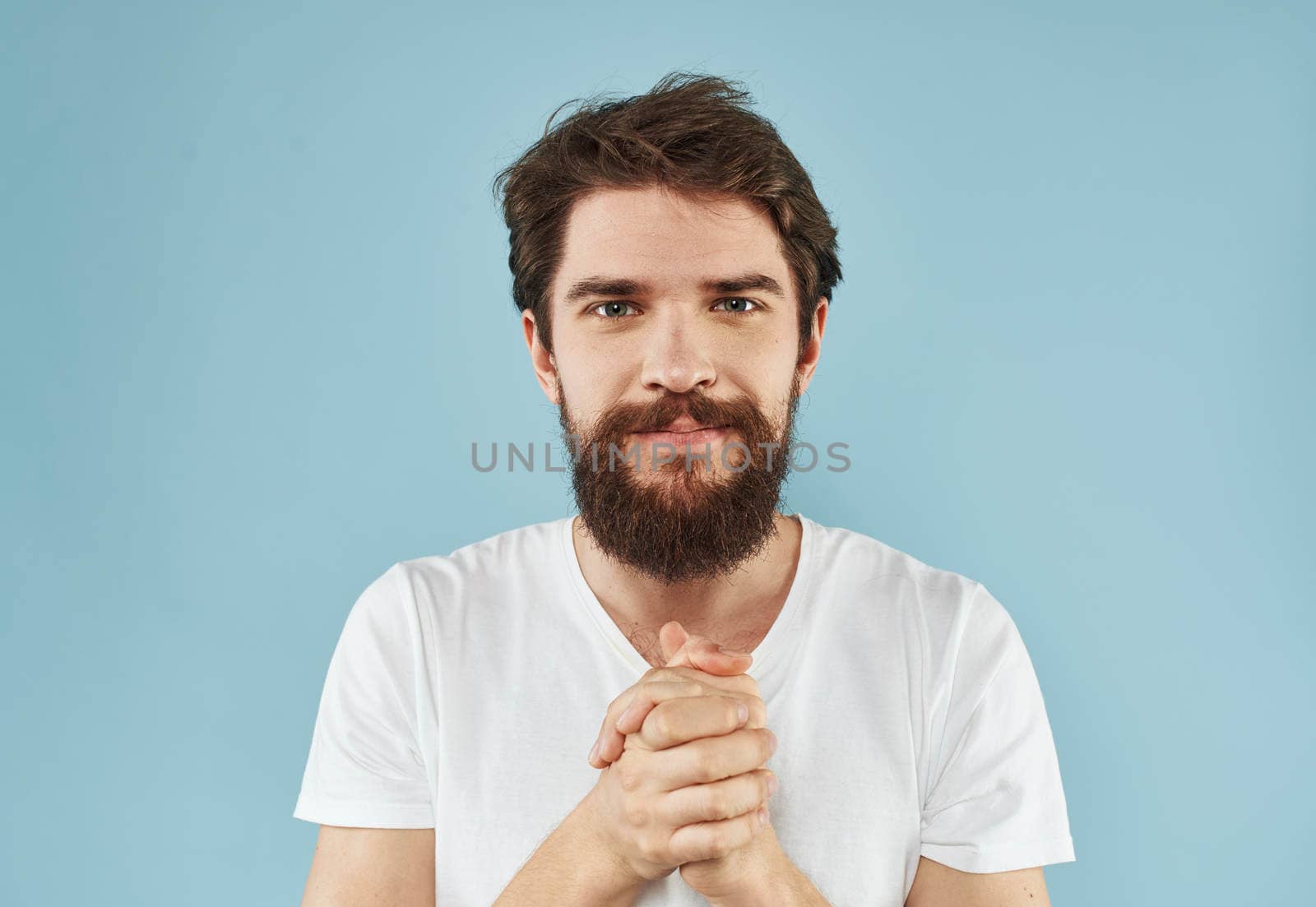 portrait of happy man on blue background in white t-shirt with open mouth emotions. High quality photo