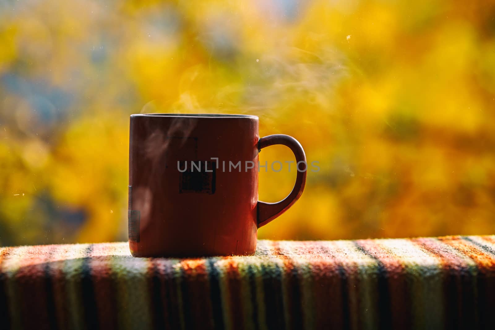 Red coffee cup over autumn background