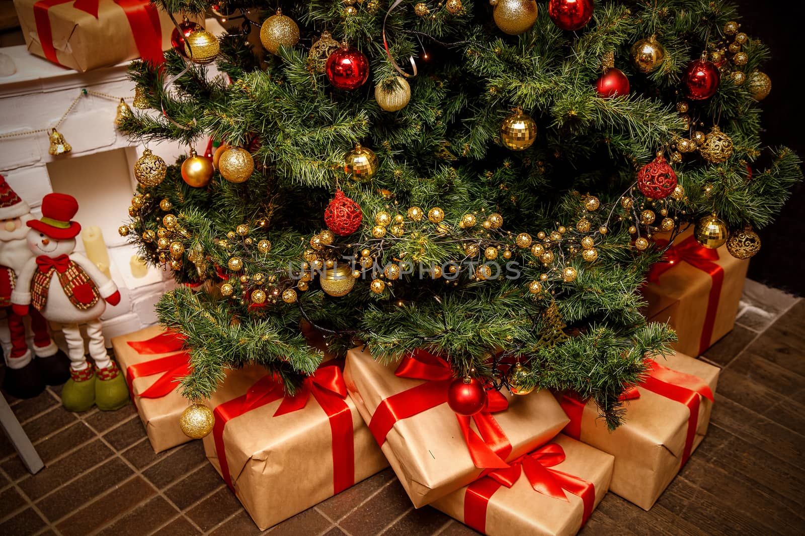 Beautiful Christmas gift boxes on floor near fir tree in the room. by 9parusnikov