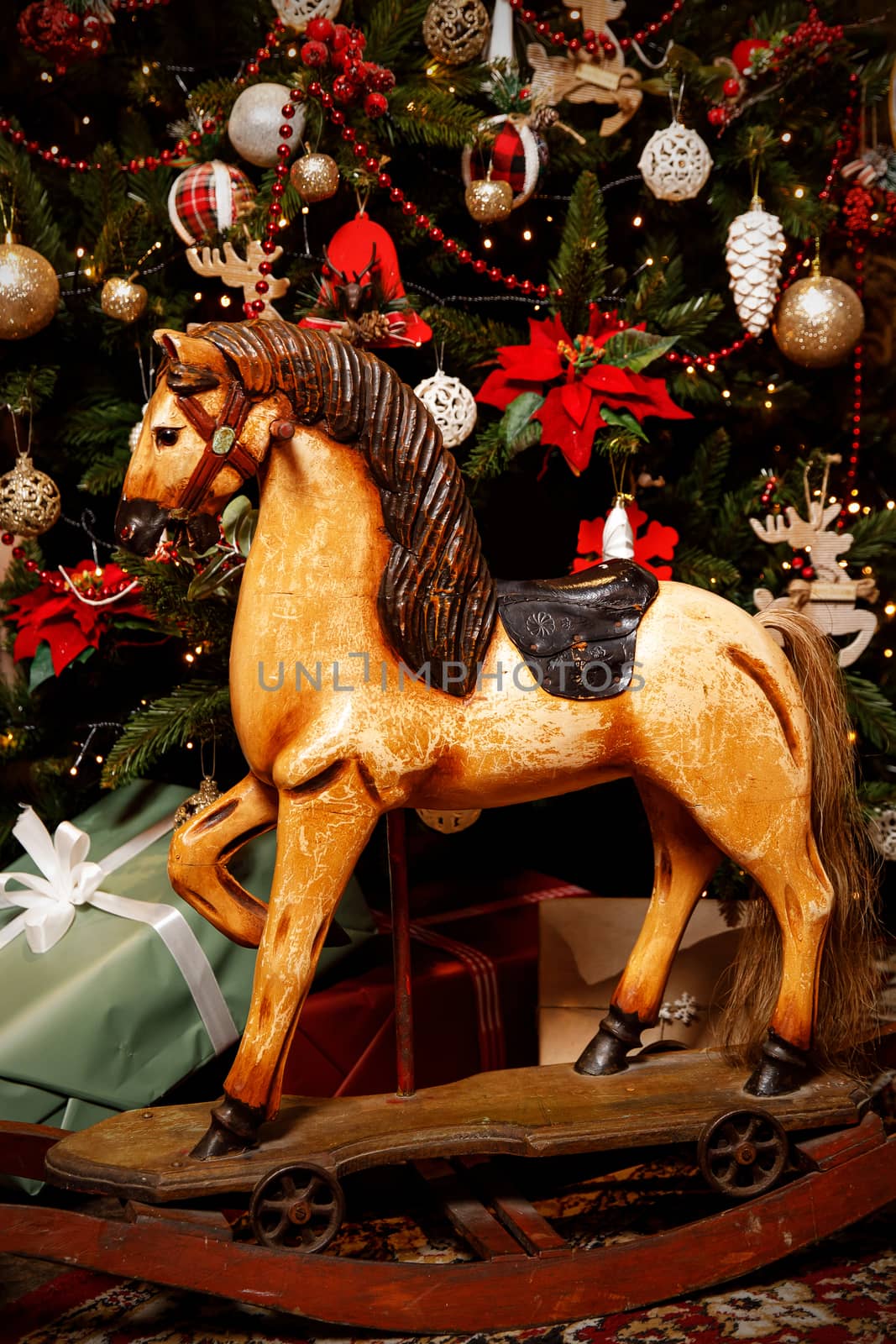 Vintage old rocking horse on a Christmas tree background. by 9parusnikov