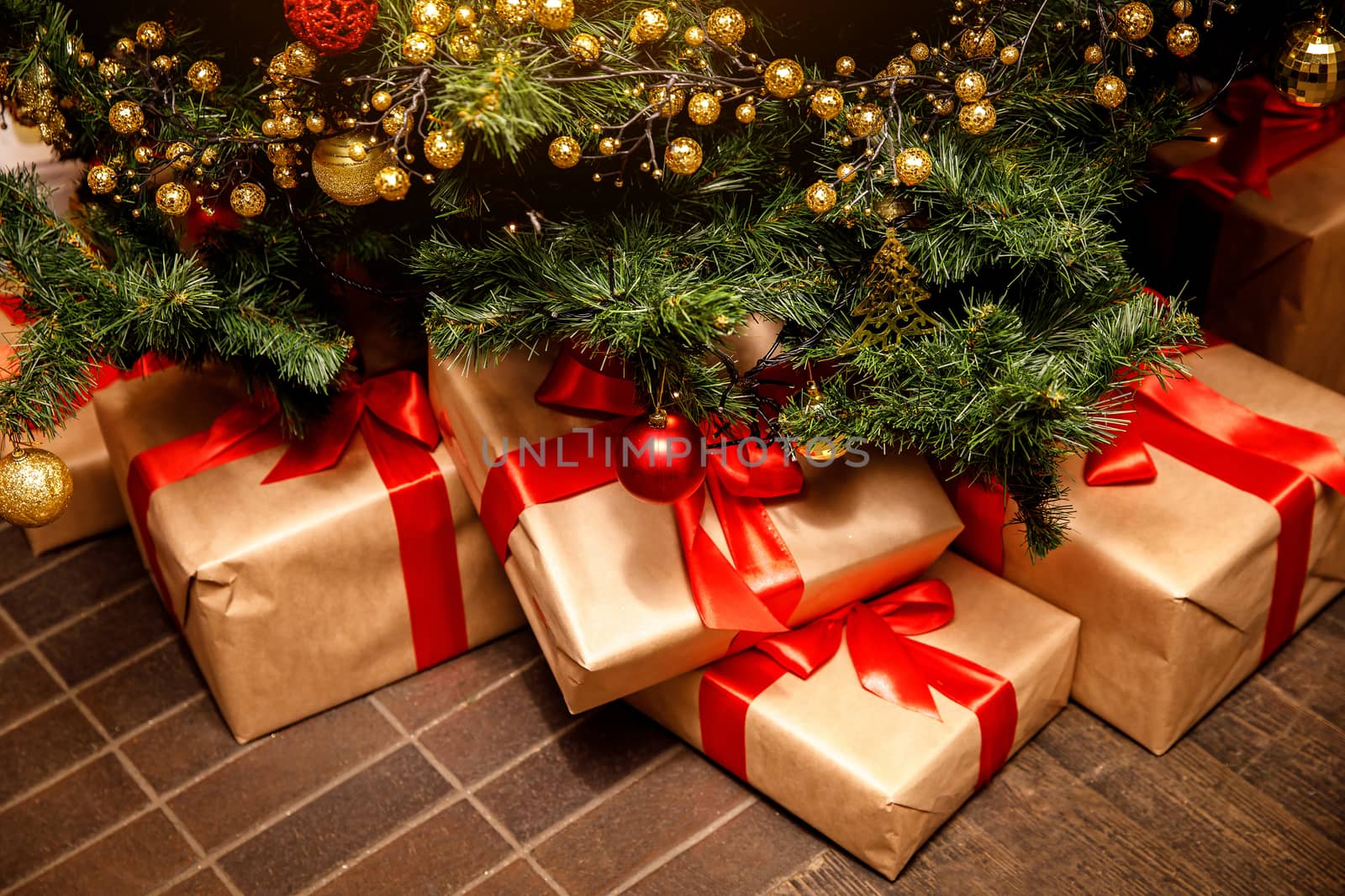 Beautiful Christmas gift boxes on floor near fir tree in the room