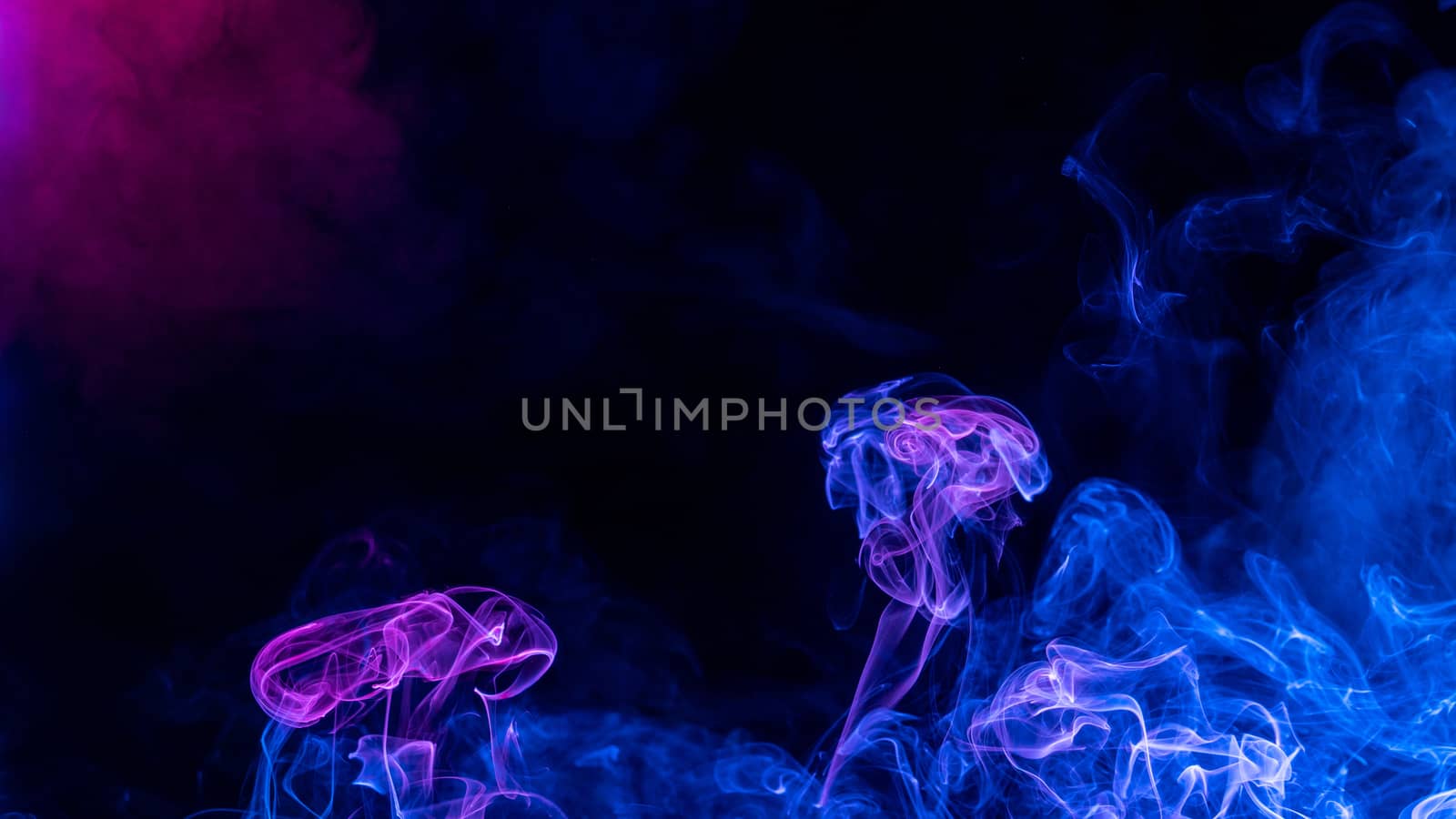 Conceptual image of colorful red and blue color smoke isolated on dark black background, Halloween concept design element.