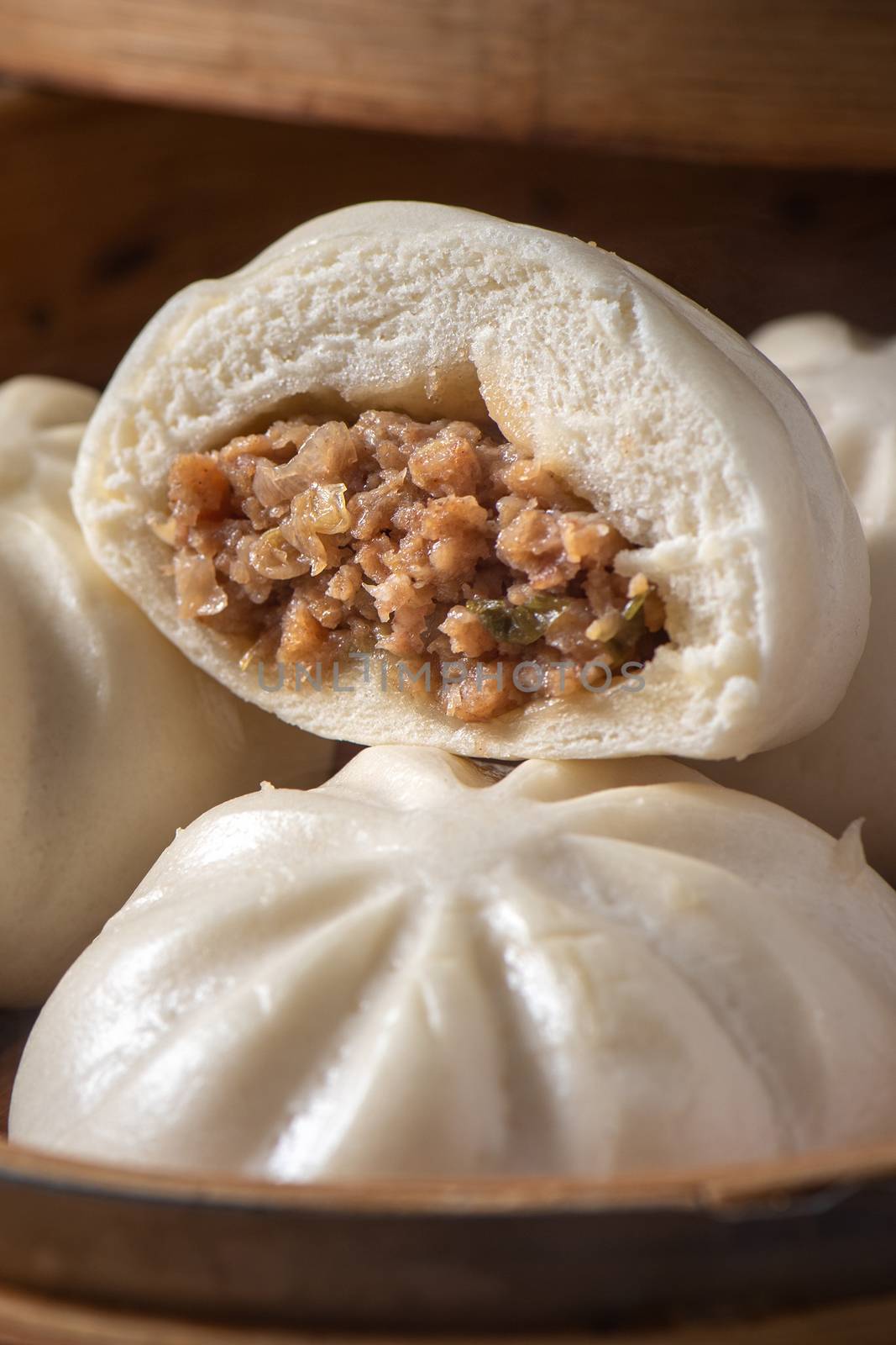 Close up of fresh delicious baozi, Chinese steamed meat bun is ready to eat on serving plate and steamer, close up, copy space product design concept.