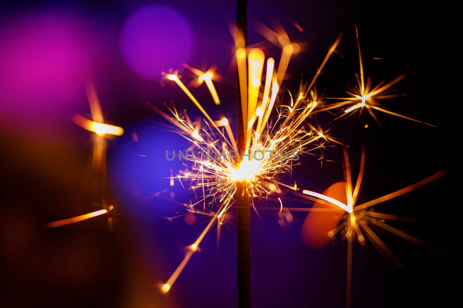 Christmas sparkler close up, Bengal light on blue background