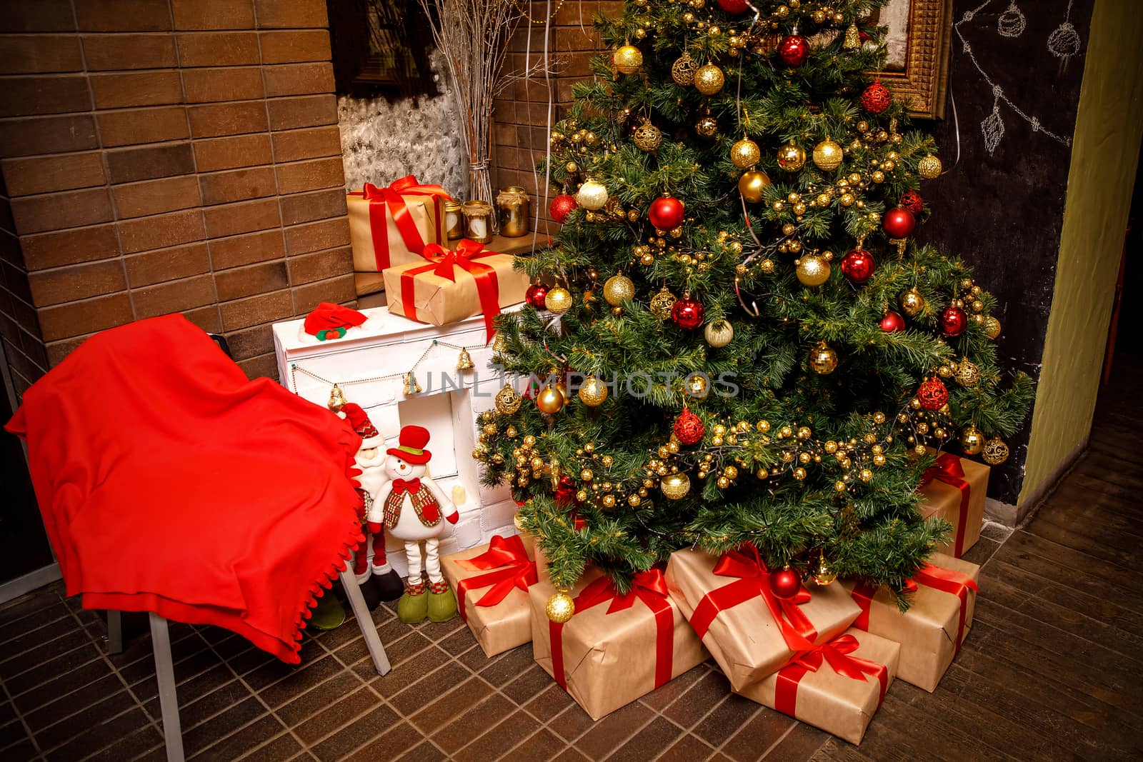 Beautiful Christmas gift boxes on floor near fir tree in the room