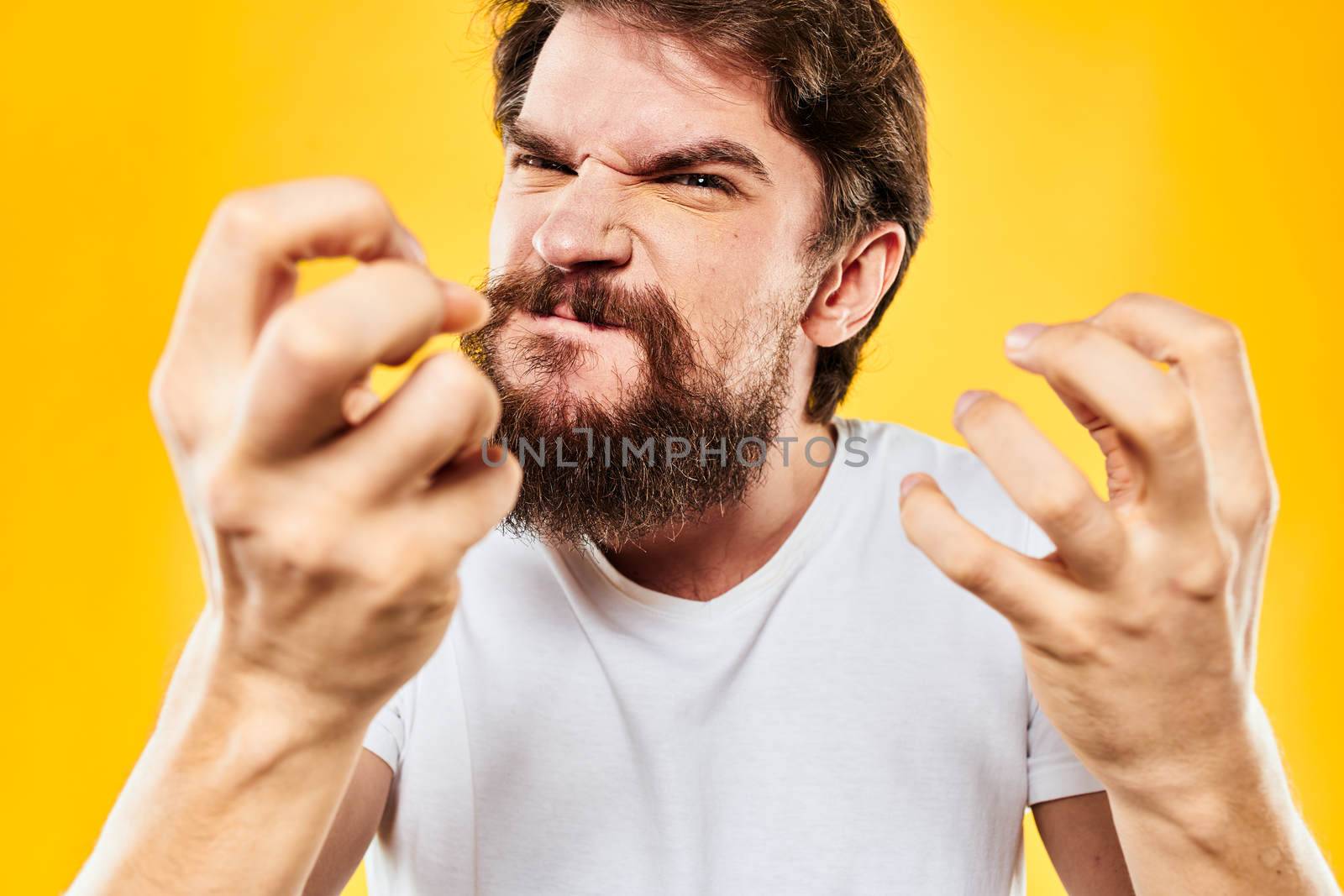 bearded man gesturing with hands studio lifestyle discontent yellow background. High quality photo