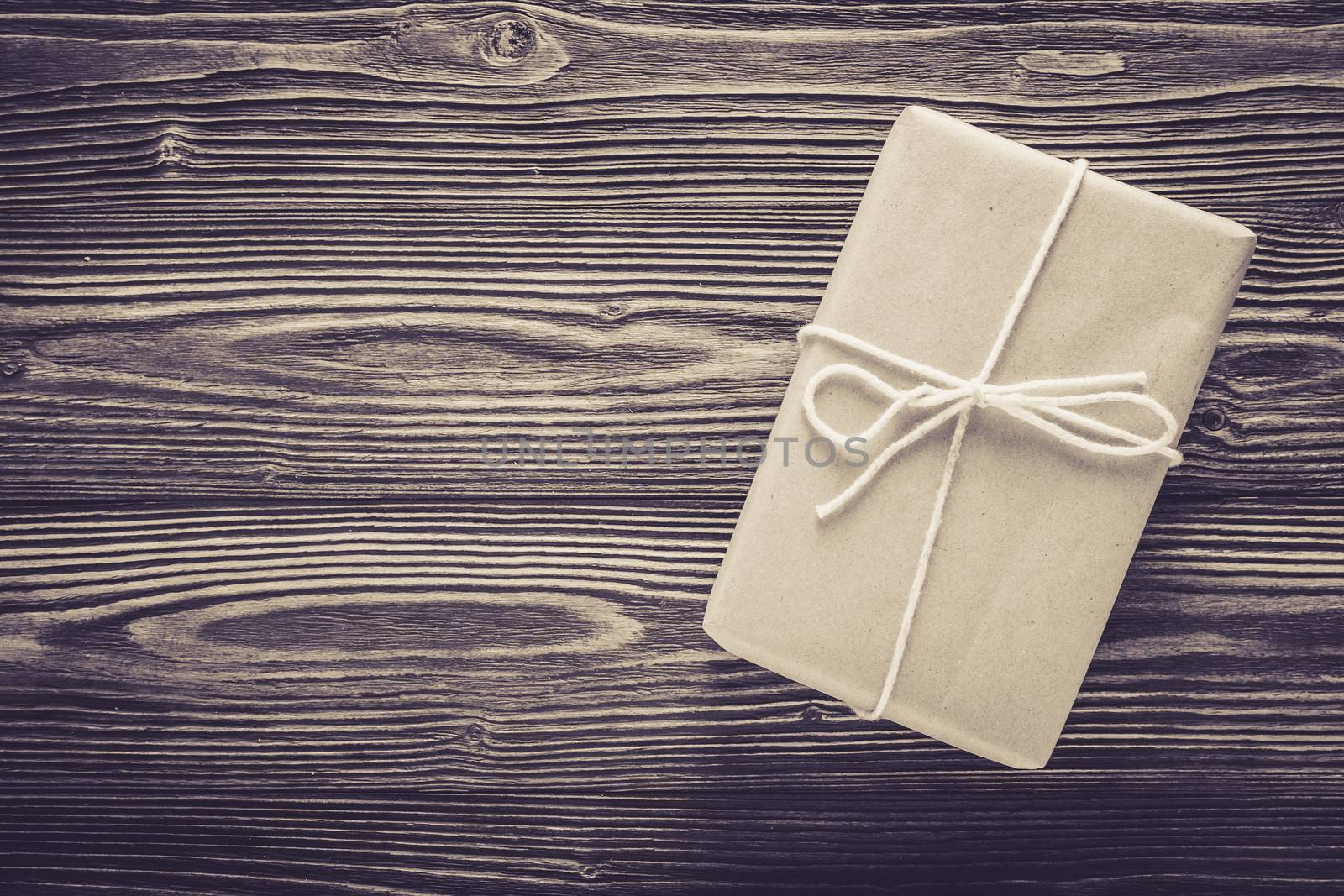 Above package gift box and rope on wood table texture background with birthday copy space, top view, holiday celebration concept.