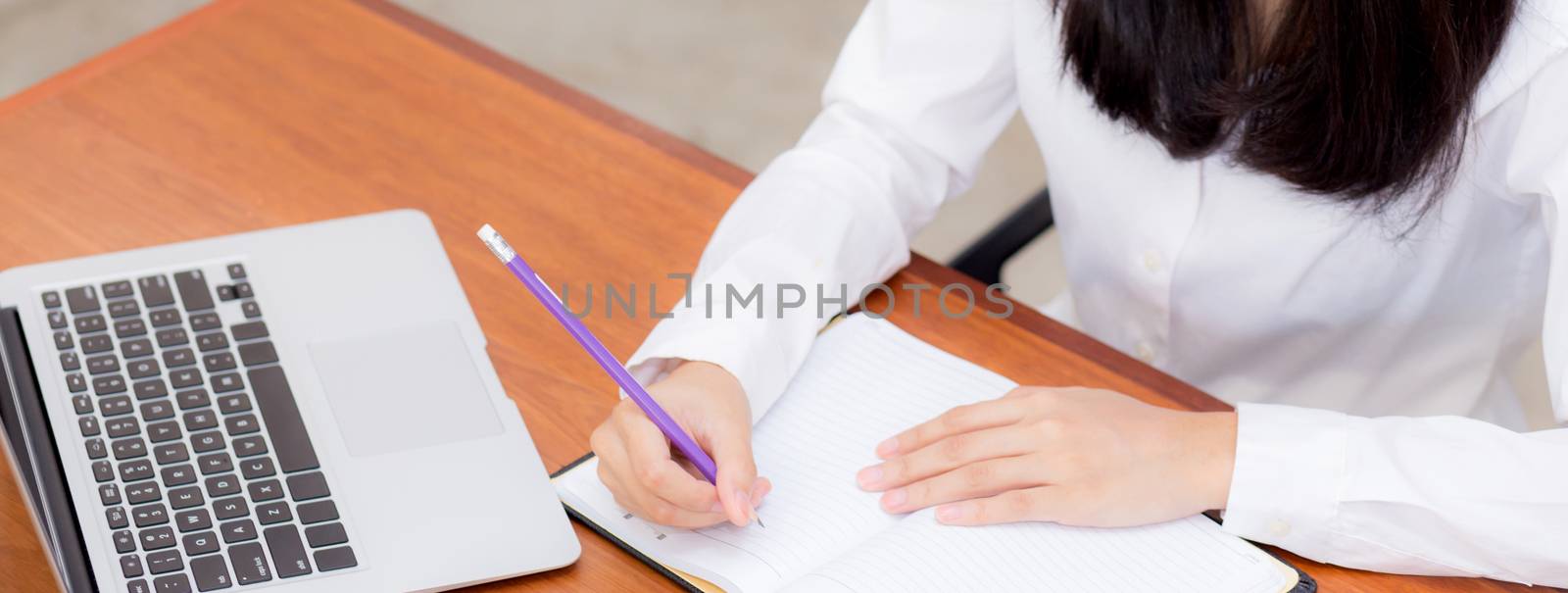 Banner closeup business asian woman writing on notebook on table with laptop, girl work at coffee shop, freelance business concept, top view.