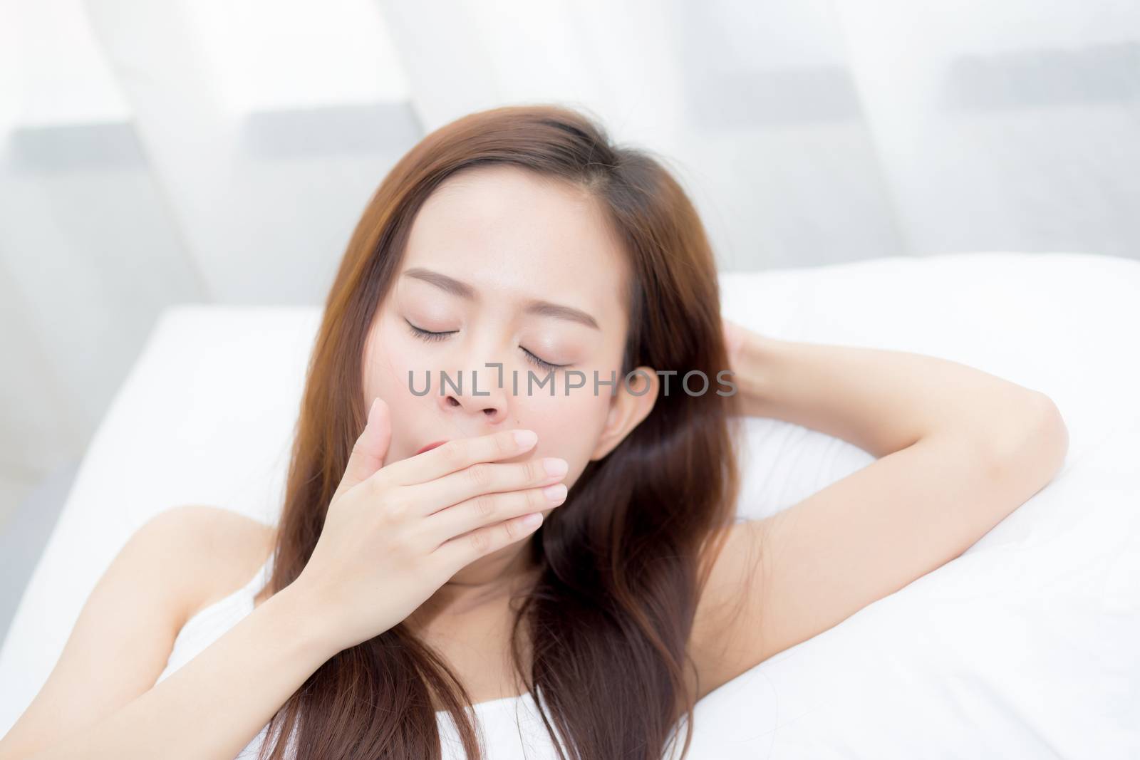 Portrait of beautiful asian young woman sleep lying in bed with head on pillow comfortable and yawn with leisure, girl with relax  for health and lifestyle concept.
