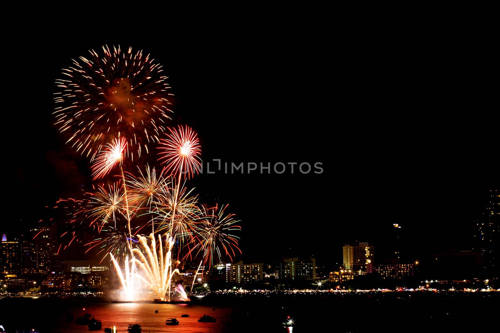 Many flashing fireworks with night cityscape background celebrate New Year.