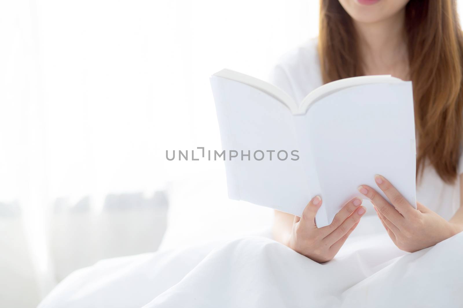 Beautiful of portrait young asian woman relax sitting reading book on bedroom at home, girl study literature, education and llifestyle concept.