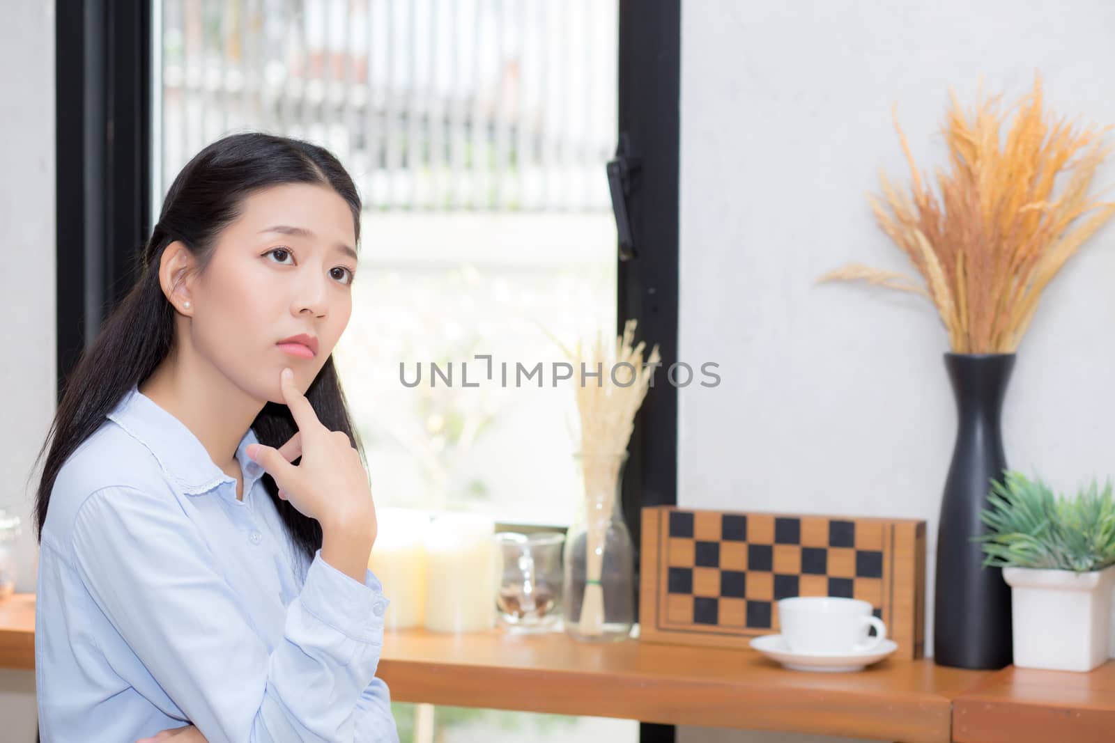 Portrait of beautiful young asian woman happiness and think sitting at cafe shop, businesswoman is a smile, freelance people concept.