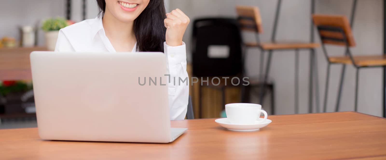 Closeup banner website asian young businesswoman excited and glad of success with laptop, girl using working computer coffee shop on desk, career freelance business concept.