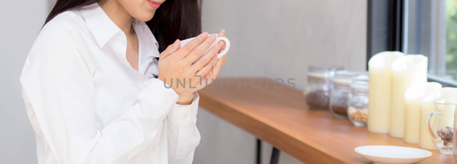closeup banner website young asian woman drinking coffee and smile in the morning at cafe, girl sitting in coffee shop for breakfast and leisure during free time.