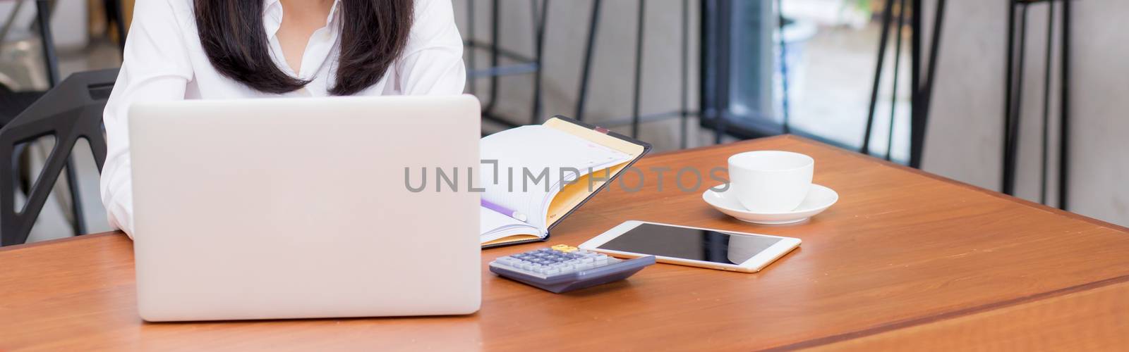 Closeup banner asian young woman working online on laptop sitting at coffee shop, professional female freelancer using notebook computer with connect to internet for distance job.