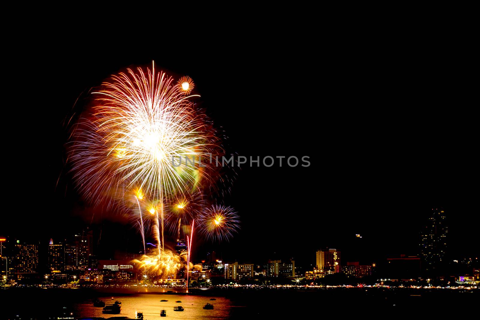 Many flashing fireworks with night cityscape background celebrate New Year.