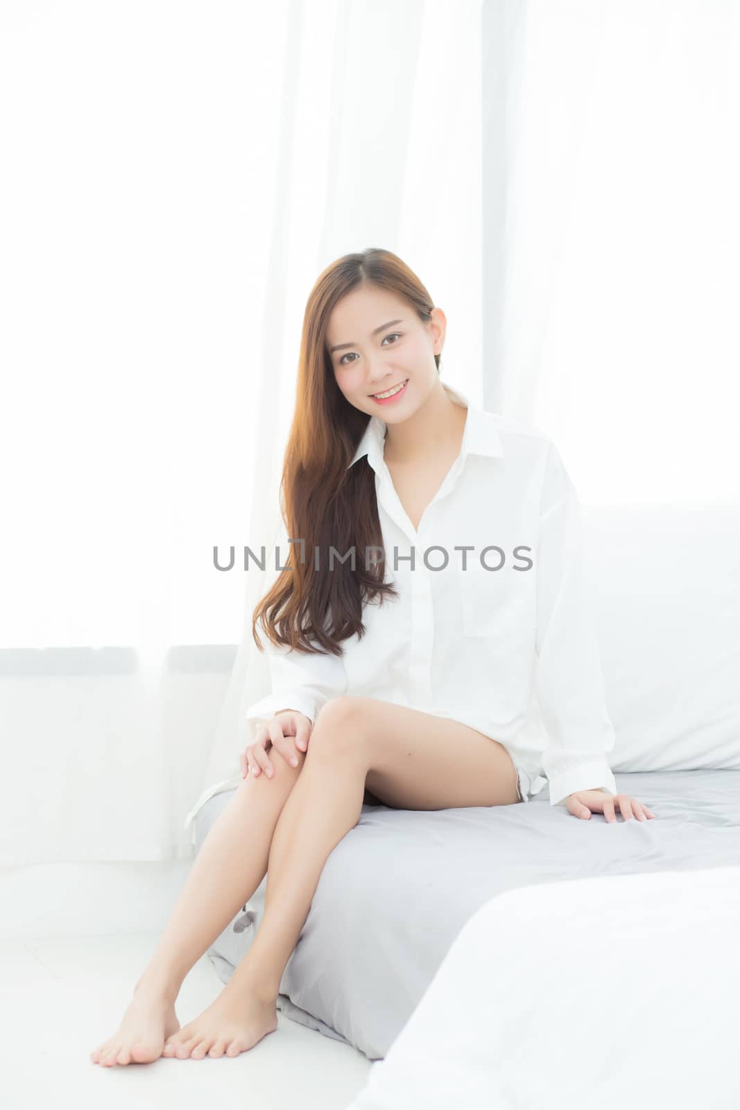 Portrait of beautiful young asian woman standing the window and  by nnudoo