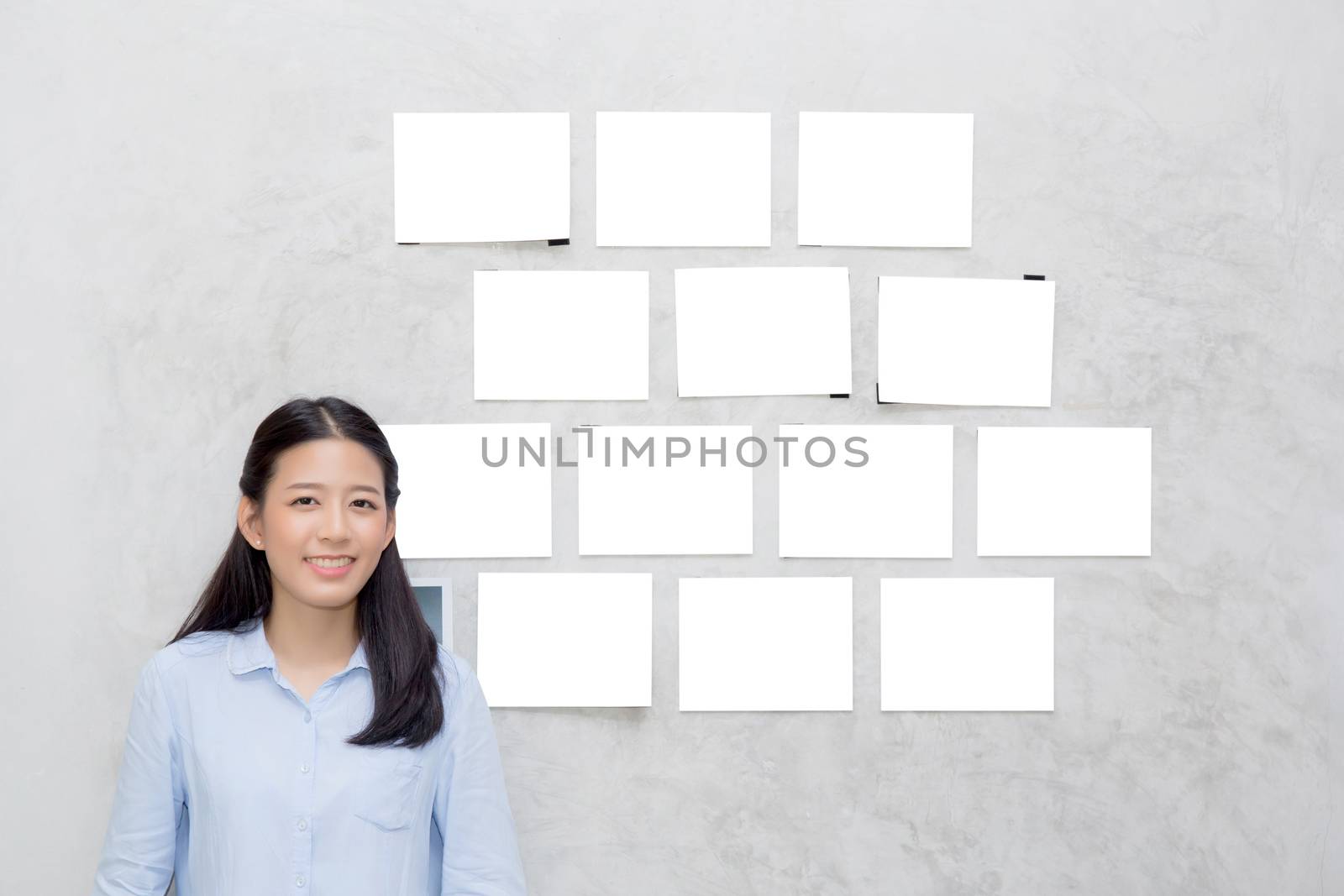 Beautiful of portrait asian young woman standing with picture gallery copy space on wall texture cement background.