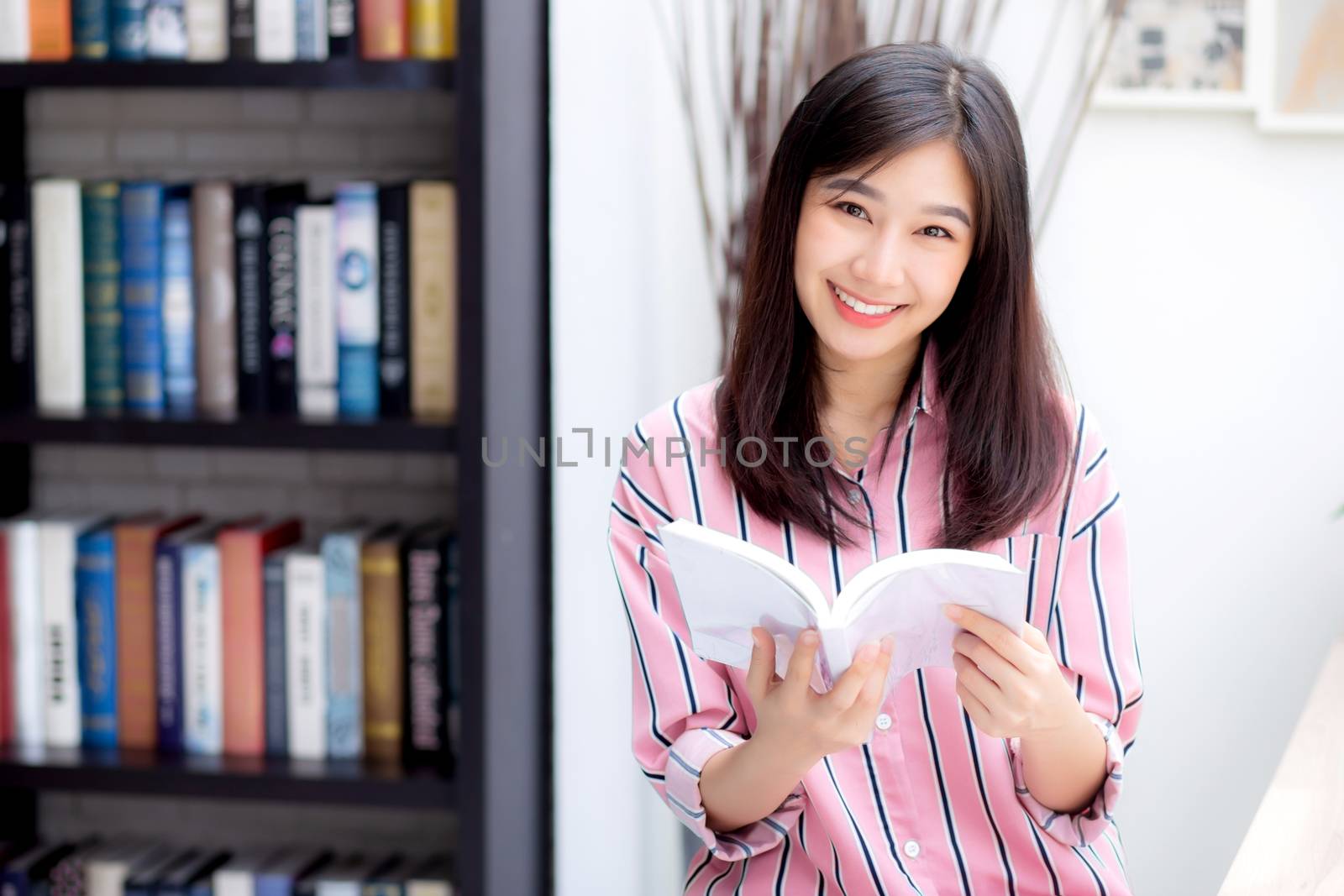 Beautiful of portrait young asian woman relax sitting reading book in living room at home, girl study literature, education and llifestyle concept.