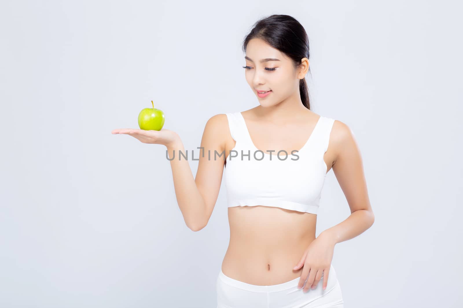 Portrait young asian woman smiling holding green apple fruit and beautiful body diet with fit isolated on white background, model girl weight slim with cellulite or calories, health and wellness concept.