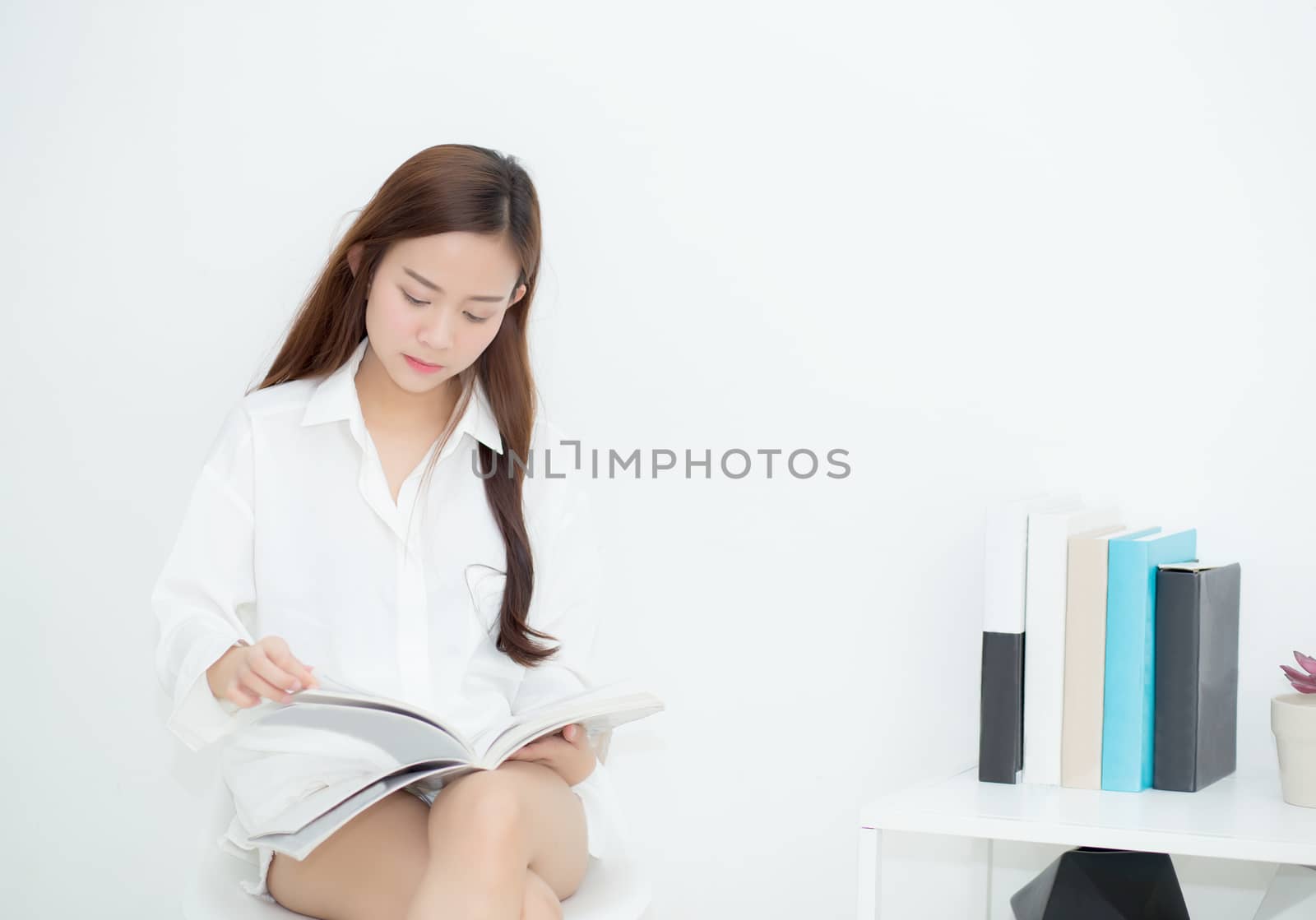 Beautiful asian young woman smile with happy reading a book, girl leisure with magazine, education concept.