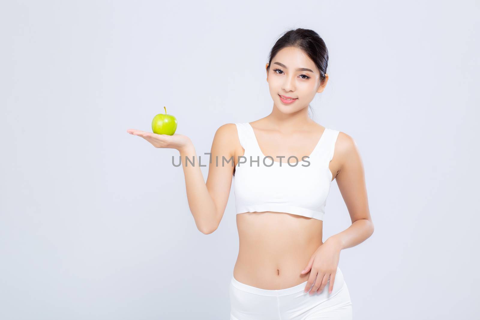 Portrait asian woman smiling holding green apple fruit and beautiful body diet with fit isolated on white background, girl weight slim with cellulite or calories, health and wellness concept.