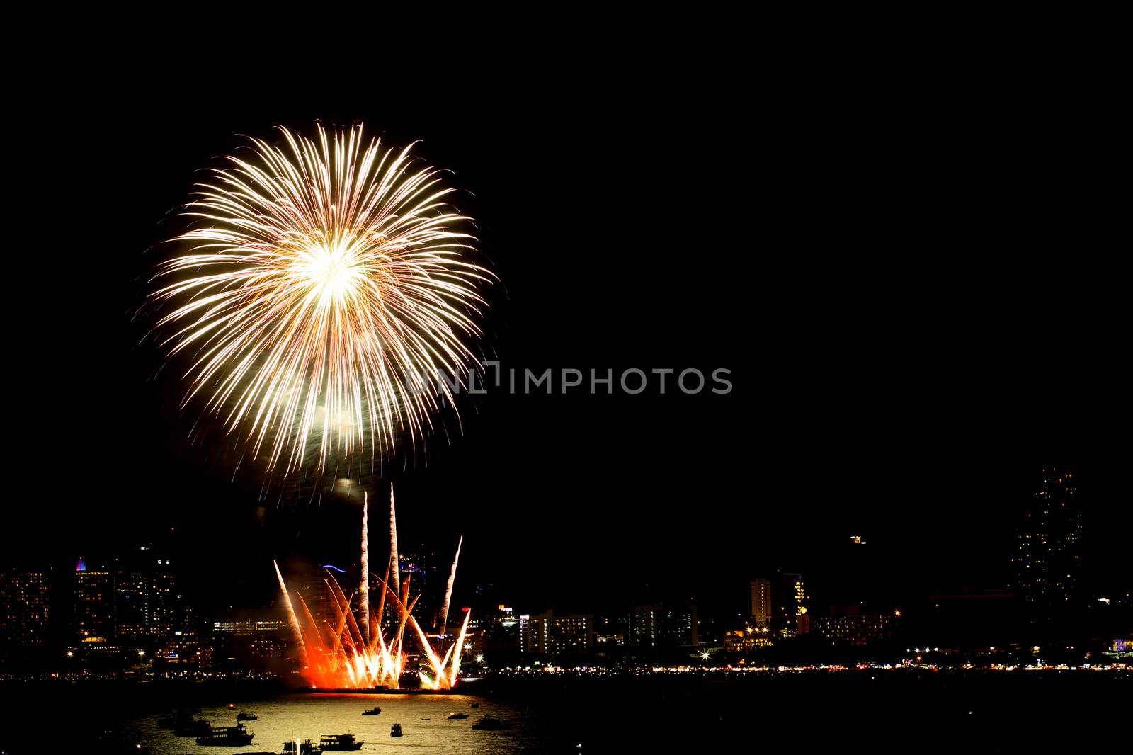 Many flashing fireworks with night cityscape background celebrate New Year.
