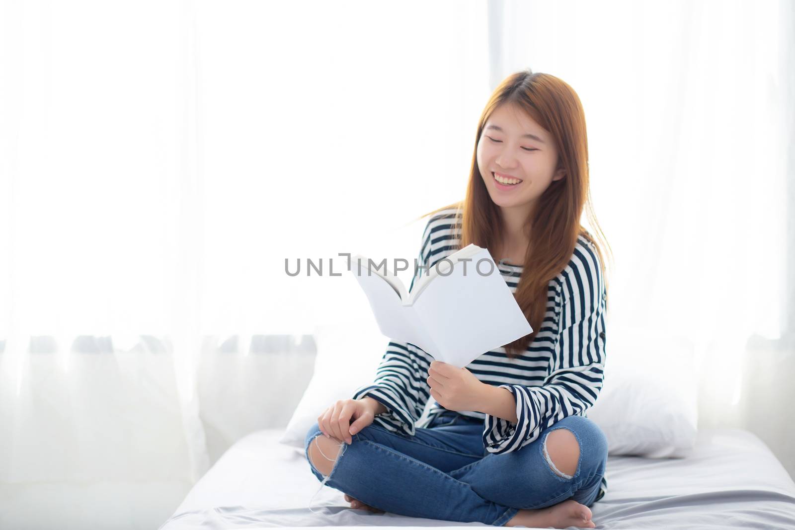 Beautiful of portrait young asian woman relax sitting reading book on bedroom at home, girl study literature, education and llifestyle concept.