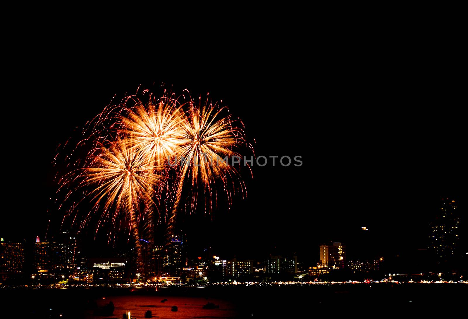 Many flashing fireworks with night cityscape background celebrate New Year.