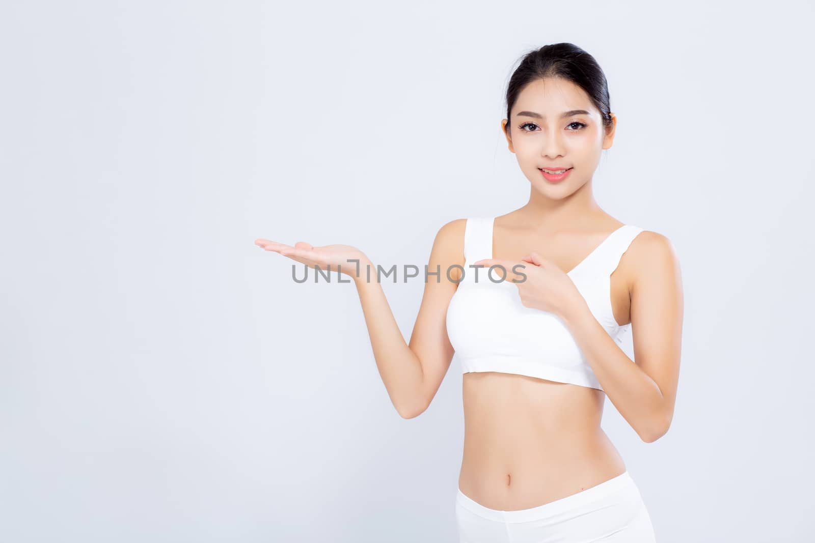 Beautiful portrait young asian woman fit smiling gesture showing presenting something empty on hand isolated on white background, healthy and diet concept.