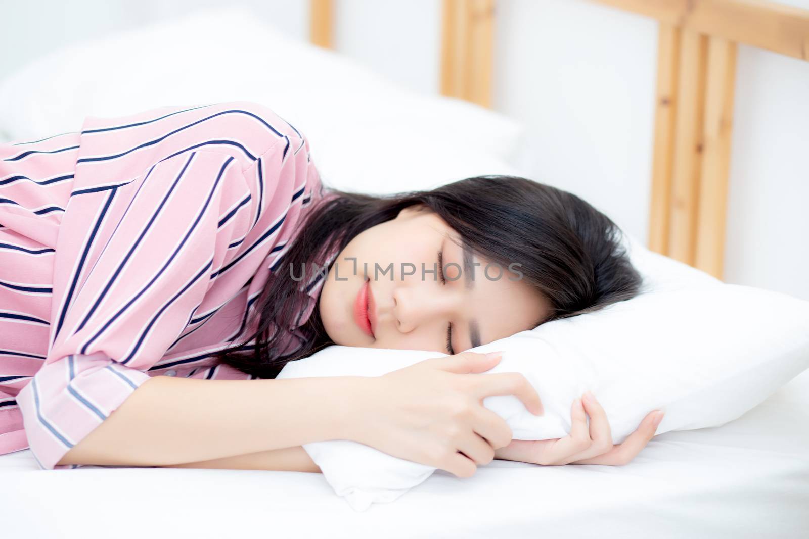 Portrait of beautiful asian young woman sleep lying in bed with head on pillow comfortable and happy with leisure, girl with relax  for health and lifestyle concept.