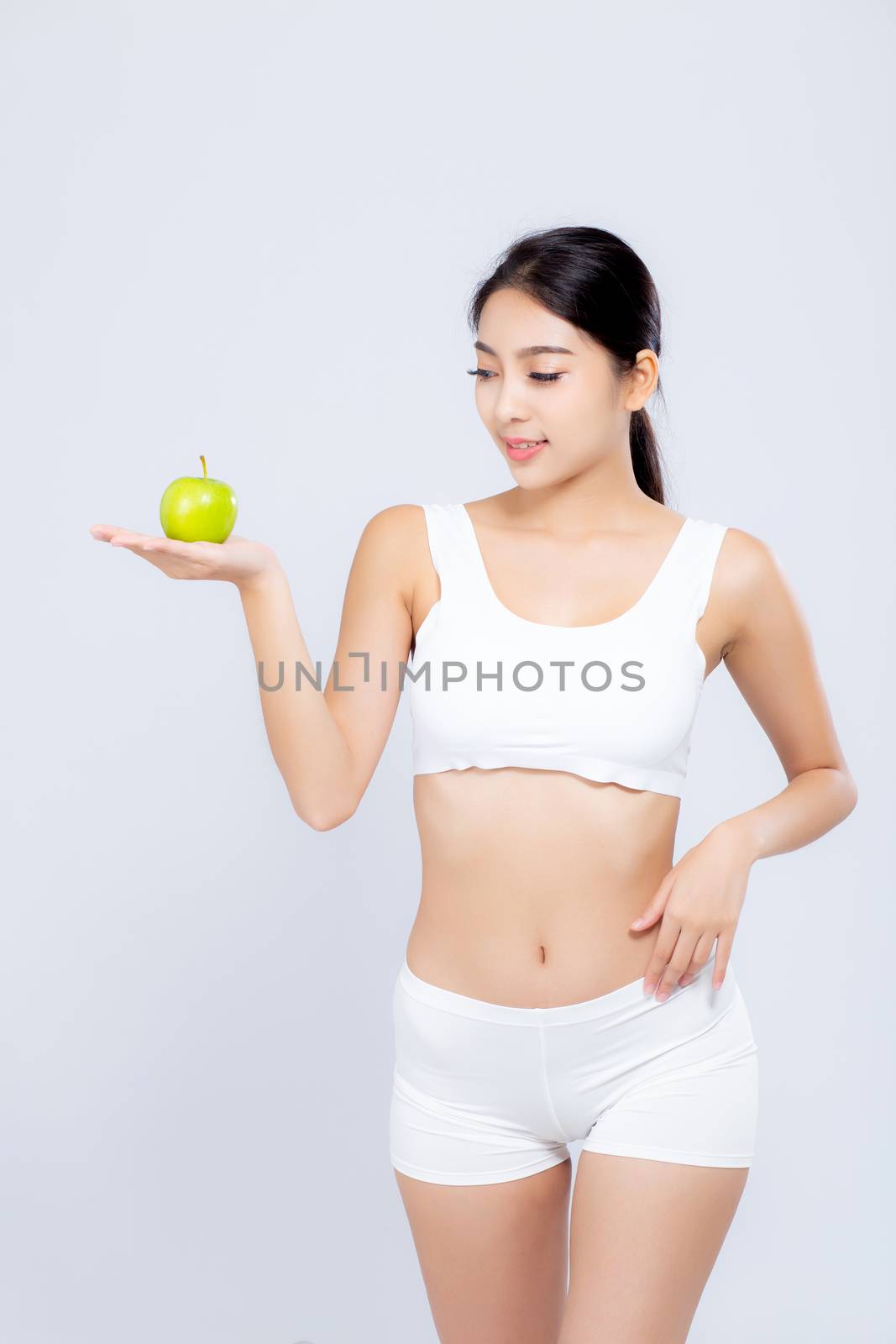 Portrait asian woman smiling holding green apple fruit and beautiful body diet with fit isolated on white background, girl weight slim with cellulite or calories, health and wellness concept.