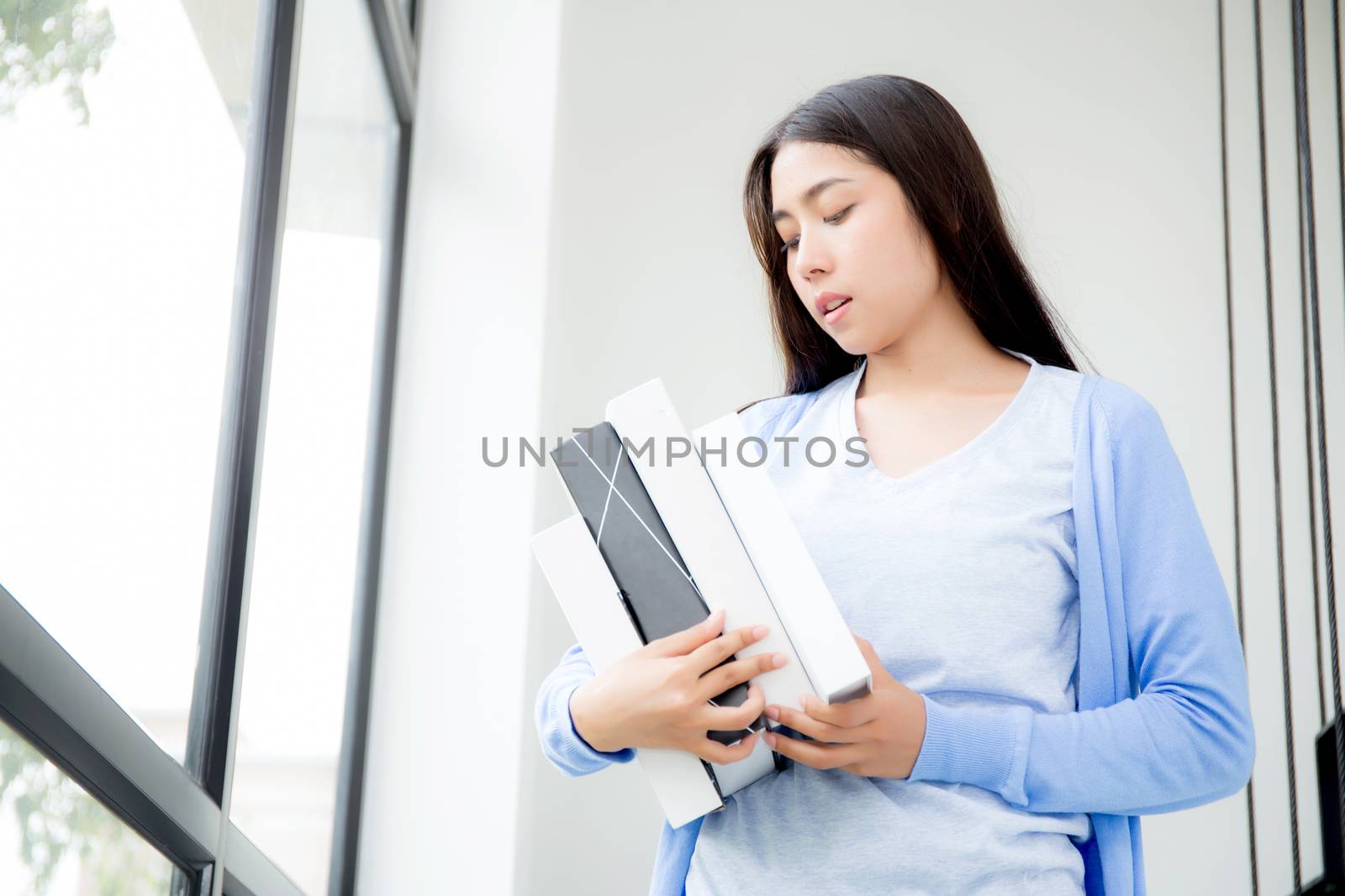 beautiful portrait young asian woman study and learning book for knowledge, girl holding book for research and searching at coworking college or university, education and lifestyle concept.