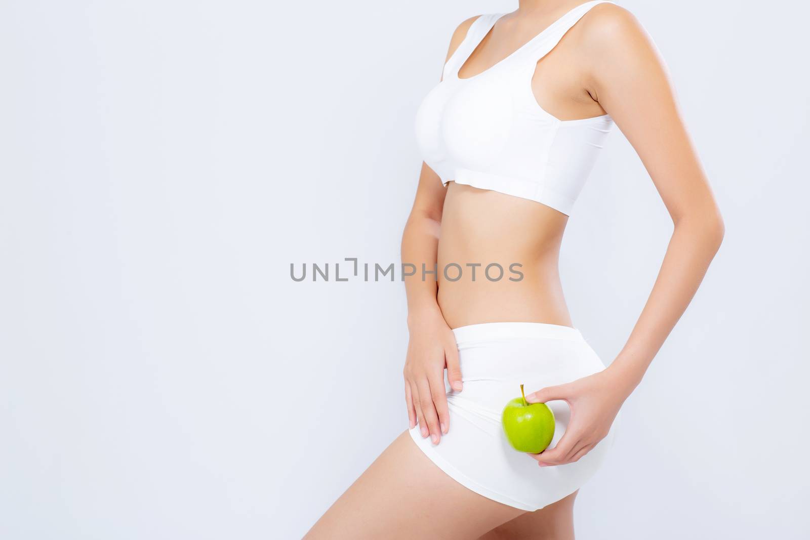 Closeup beautiful body woman sexy slim holding green apple with cellulite for wellness, girl waist thin with fitness for weight loss and healthy isolated on white background, healthcare and diet concept.