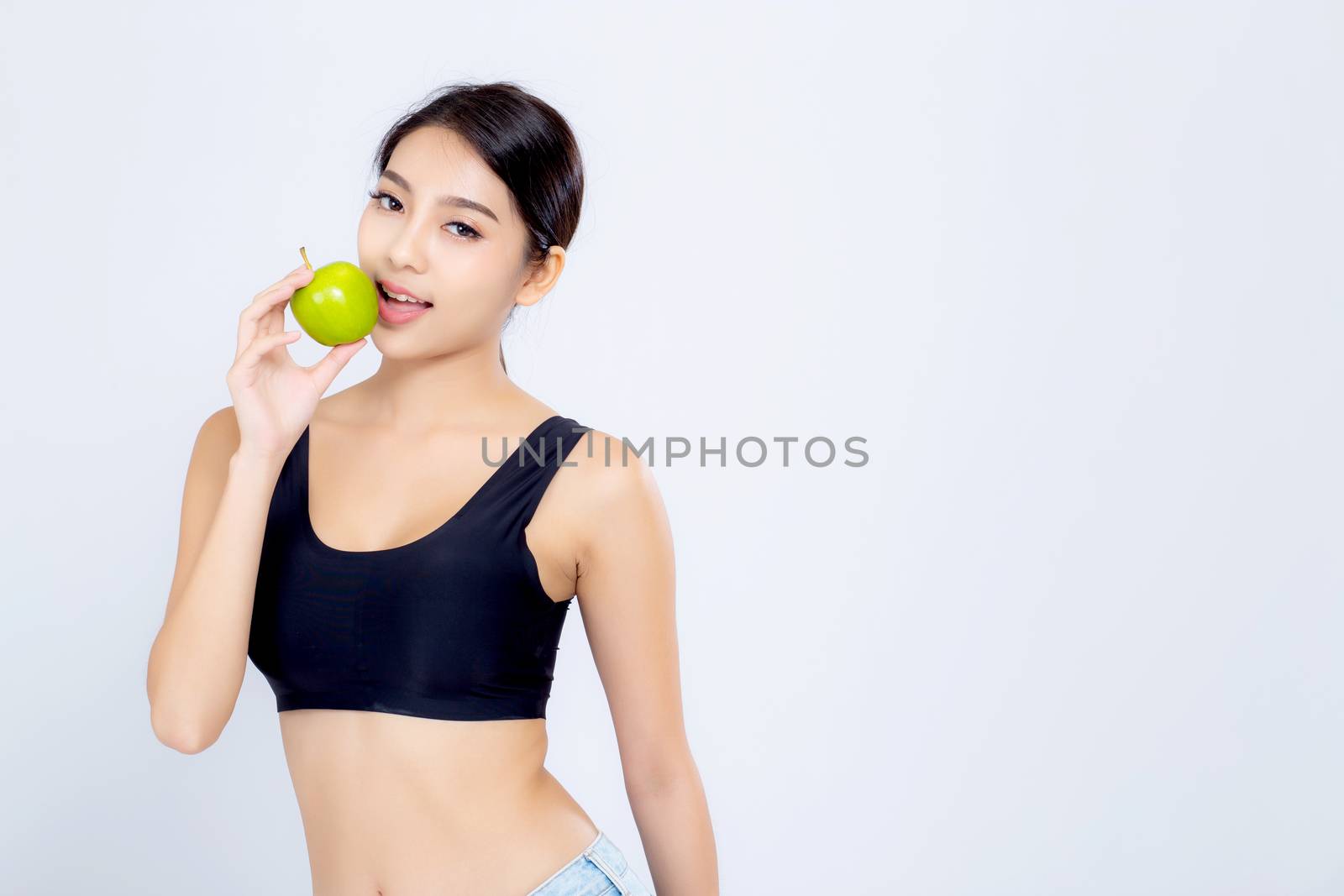 Portrait asian woman smiling holding and eating green apple fruit and beautiful body diet with fit isolated on white background, girl weight slim with cellulite or calories, health and wellness concept.