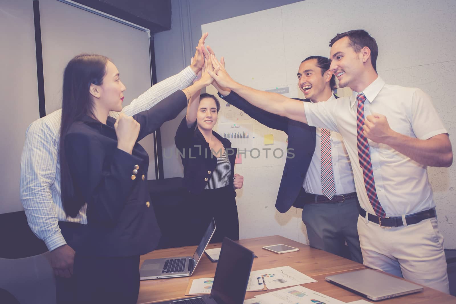 Group business asian people team with success gesture giving hi five in the meeting, agreement with achievement work of teamwork together. by nnudoo