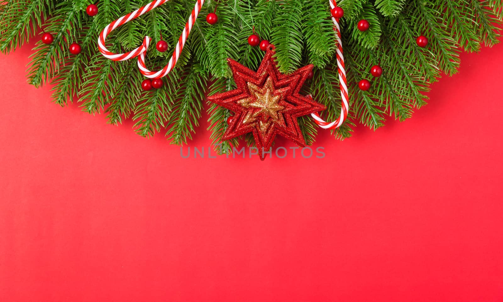 Happy new year or christmas day top view flat lay fir tree branches and ornaments decoration on red background with copy space for your text