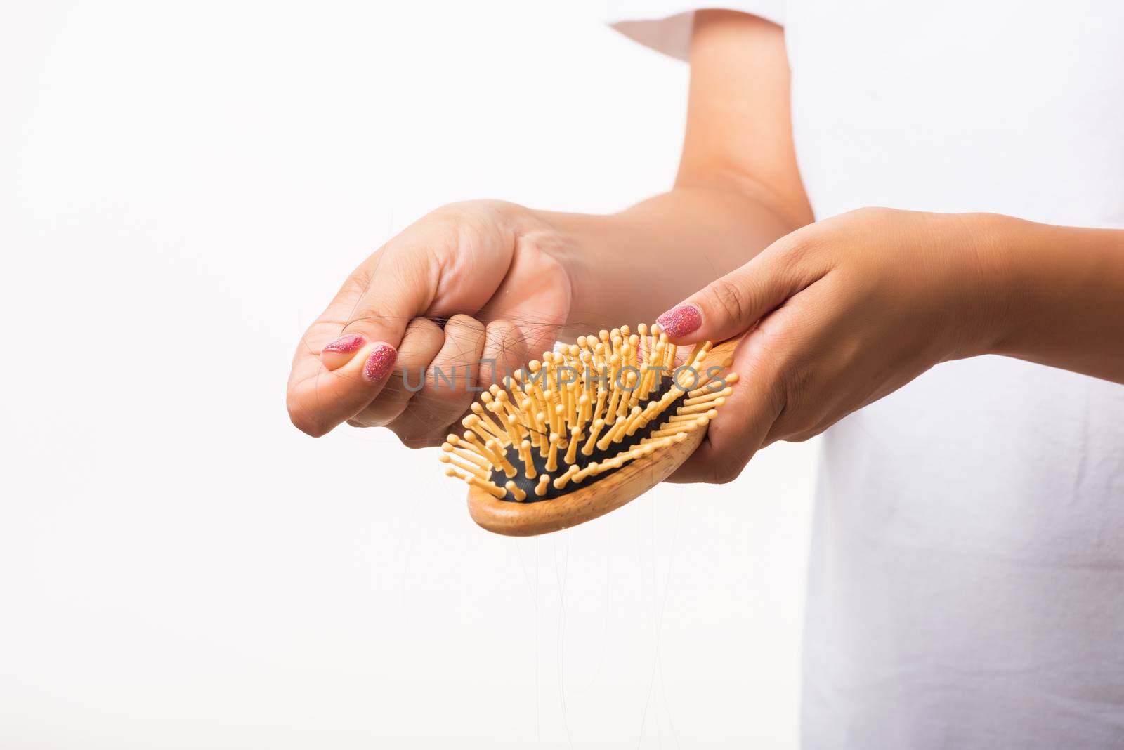 Asian woman unhappy weak hair problem her hold hairbrush with damaged long loss hair in the comb brush she pulls loss hair from the brush, isolated on white background, Medicine health care concept