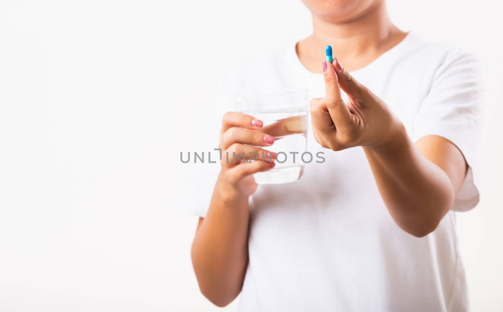 Closeup young Asian woman hold pill drugs in hand ready take medicines with a glass of water, studio shot isolated on white background, Healthcare and medical pharmacy concept