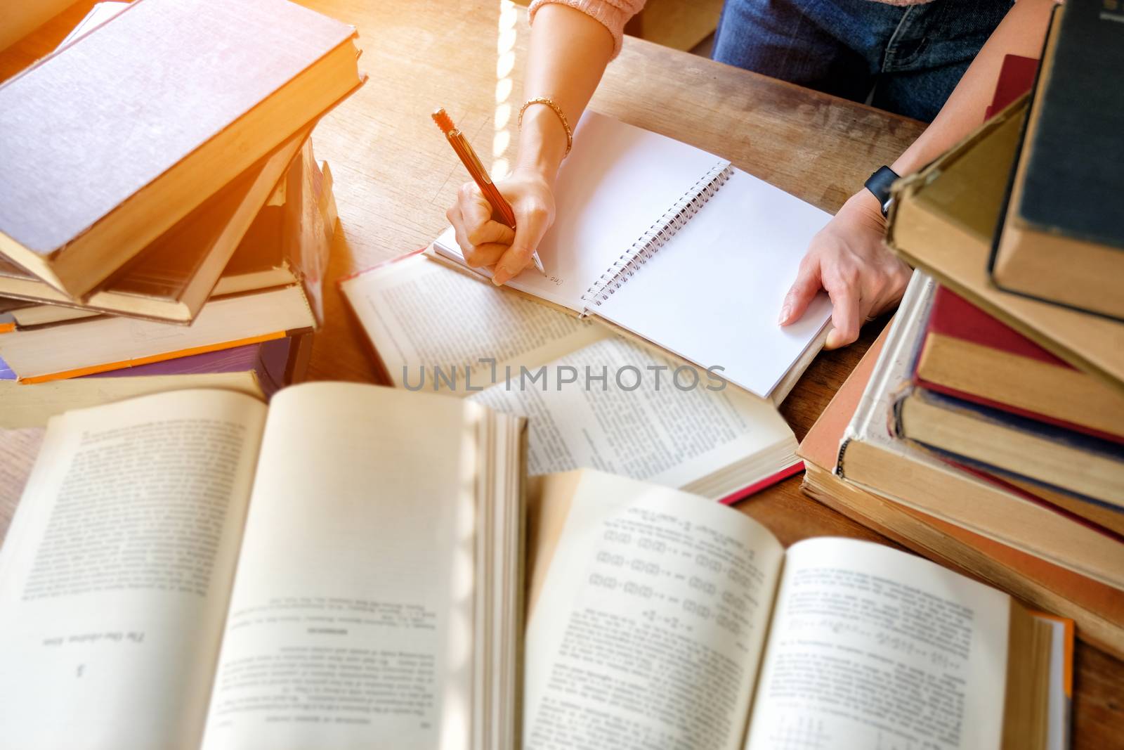 Young woman studying in library by Surasak