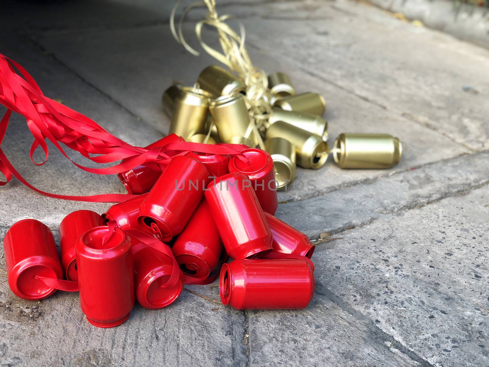 Wedding car with red and gold cans tied at the back